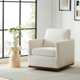 A white swivel chair next to a small side table