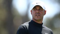 Brooks Koepka wearing a white Nike cap and black Nike mock turtleneck 