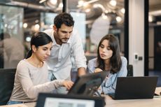 Small group of co-workers working together in a startup business office space. 