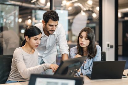 Small group of co-workers working together in a startup business office space.