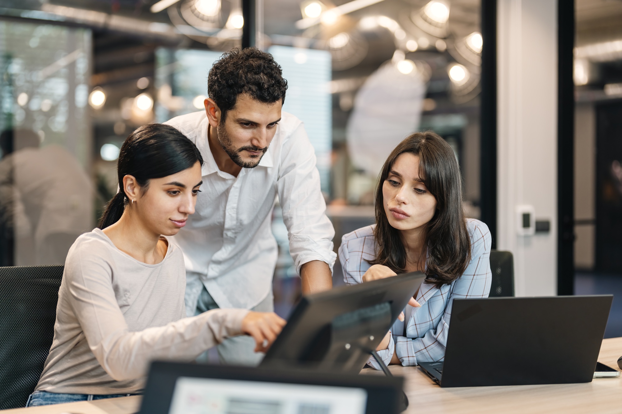 Small group of co-workers working together in a startup business office space.