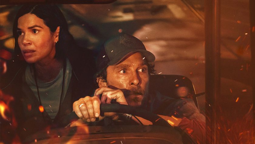 America Ferrera and Matthew McConaughey look out the window of a bus with embers around them in the movie The Lost Bus