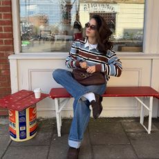 tia wears jeans and blue and burgundy striped rugby shirt