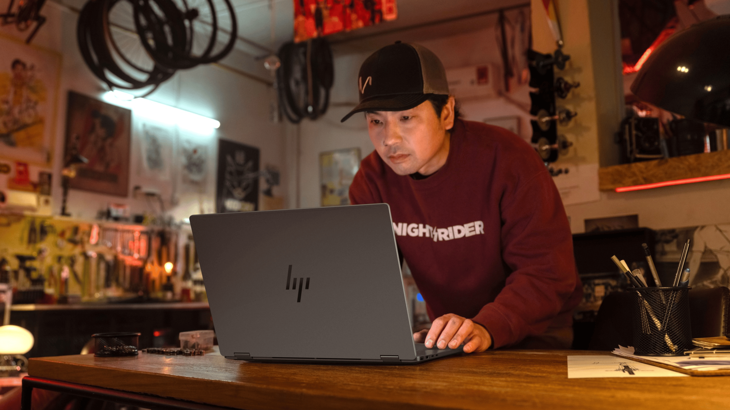 A man stands in a garage and uses the HP OmniBook.
