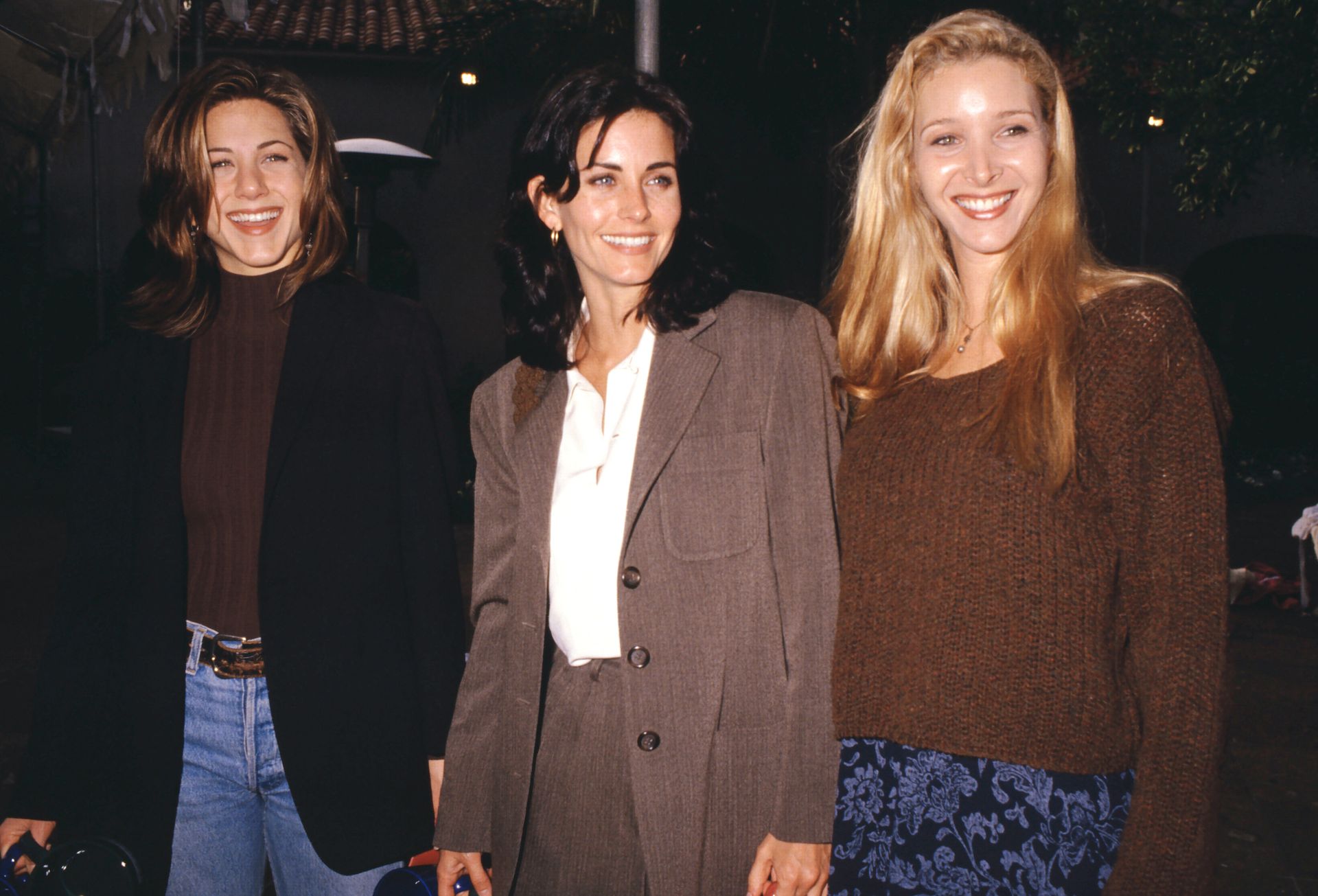 Jennifer Aniston wearing a brown mock-neck sweater.