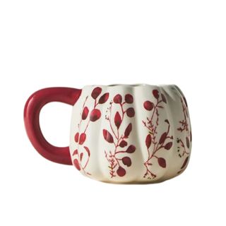 A red and white pumpkin mug with floral illustrations