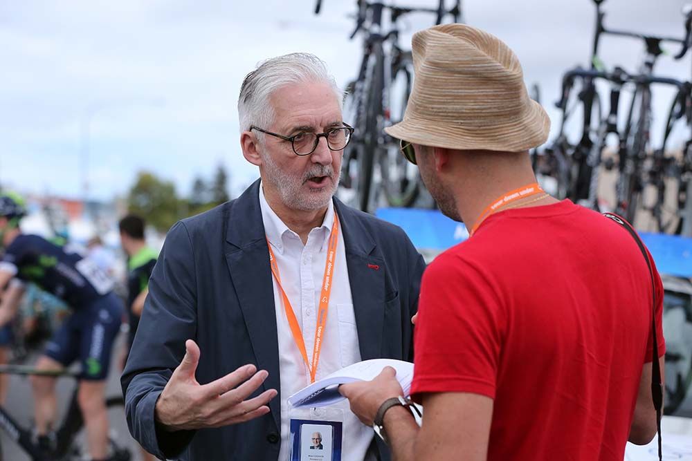 UCI President Brian Cookson talks a journalist at the start