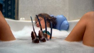 a girl in a bathtub while freddy krueger's hand emerges from the water in a nightmare on elm street