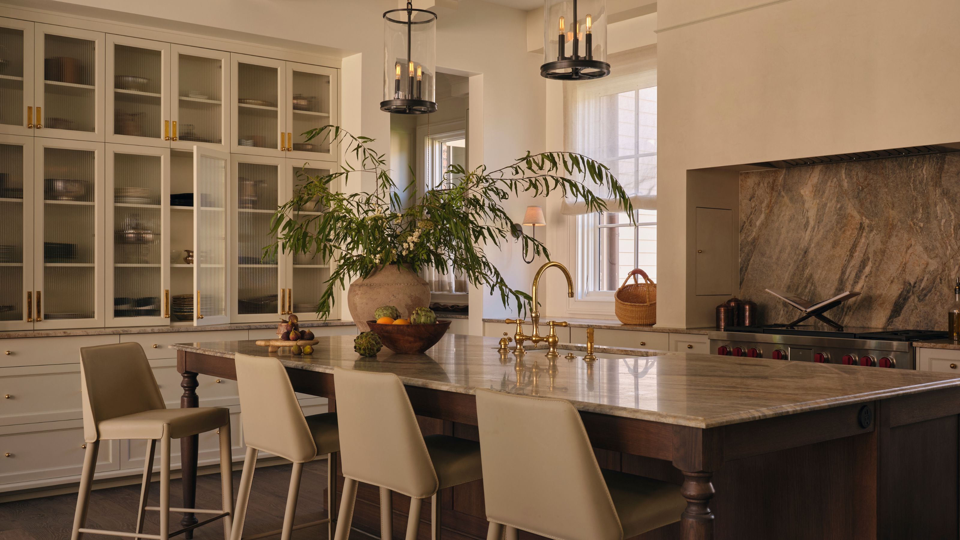a neutral traditional kitchen with dark wooden kitchen island, earthy marble stone and grass pantry style wall units