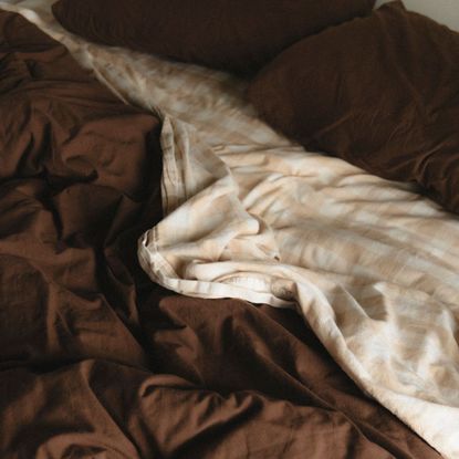 A chocolate brown duvet cover with gingham sheet
