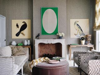 Gray living room with striped accent chairs and two bird paintings on the wall