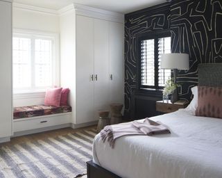 White bedroom with black feature wall with window seat