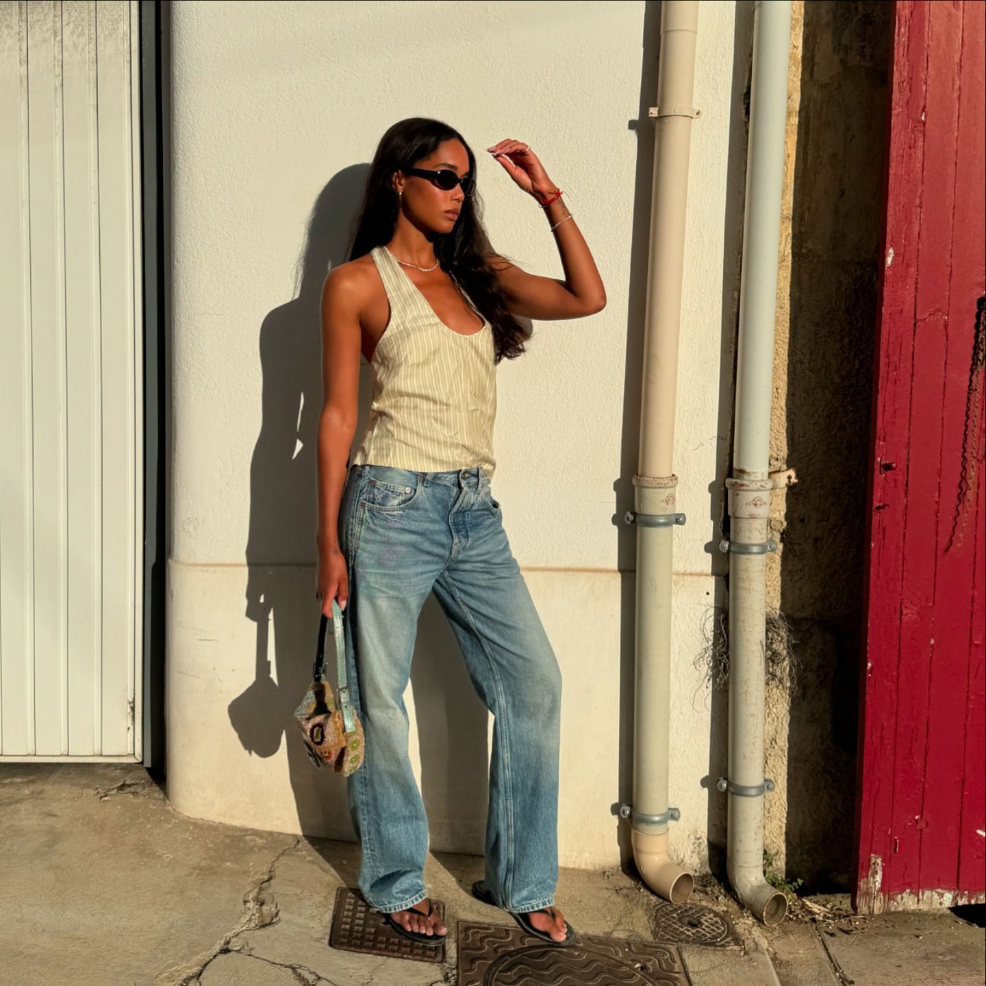 Laura Harrier wears flip flops and a tank top.