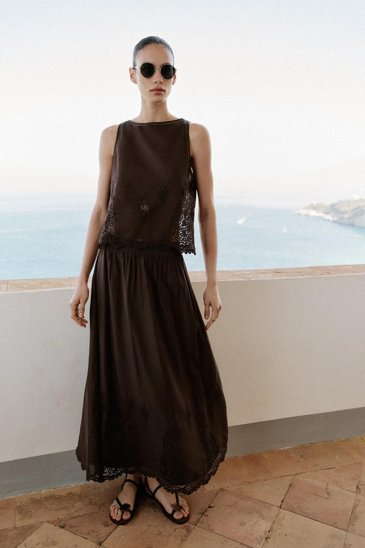 Woman wears brown satin set with lace details.