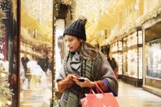 Woman is window shopping in decorated street.