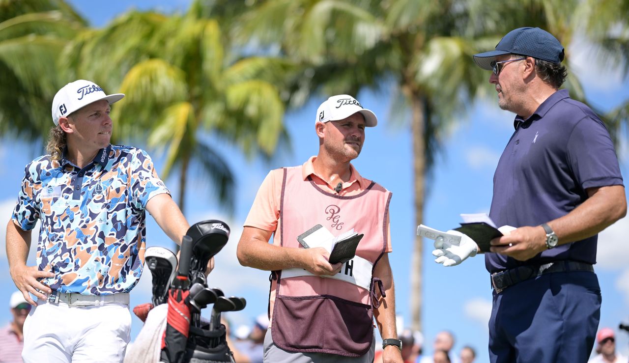 Smith and Mickelson chat on the tee while Smith&#039;s caddie looks on 