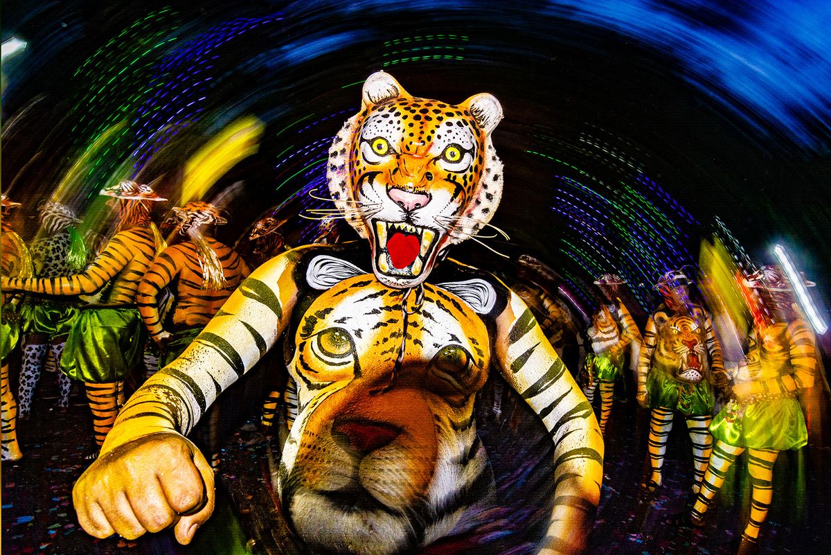 &#039;Tiger dancer&#039; performing Pulikali during India&#039;s Onam festival, with spiral of lights behind