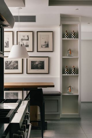 breakfast table at end of kitchen with gallery wall and open shelving