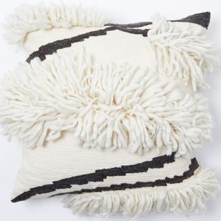 fringed white cushion