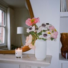 a picture of a Jo Malone candle next to a vase of flowers