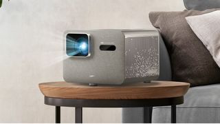 BenQ TK705i projector on a small table next to a couch