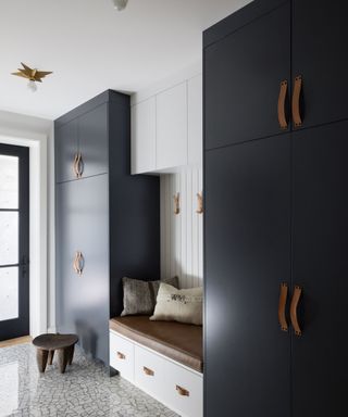 mud room with black cupboards and bench seat