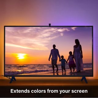A large TV with a sunset on screen. The Sengled Wifi Video-Sync LED light strip mirrors the colors on the TV screen across the whole room.