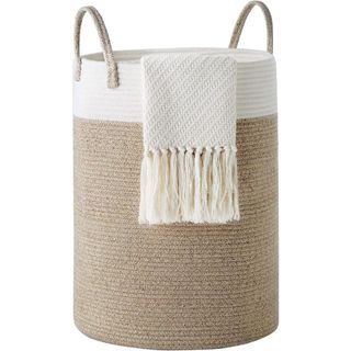 A woven laundry basket with handles and a towel