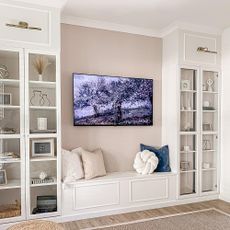 living area with white cabinets and television