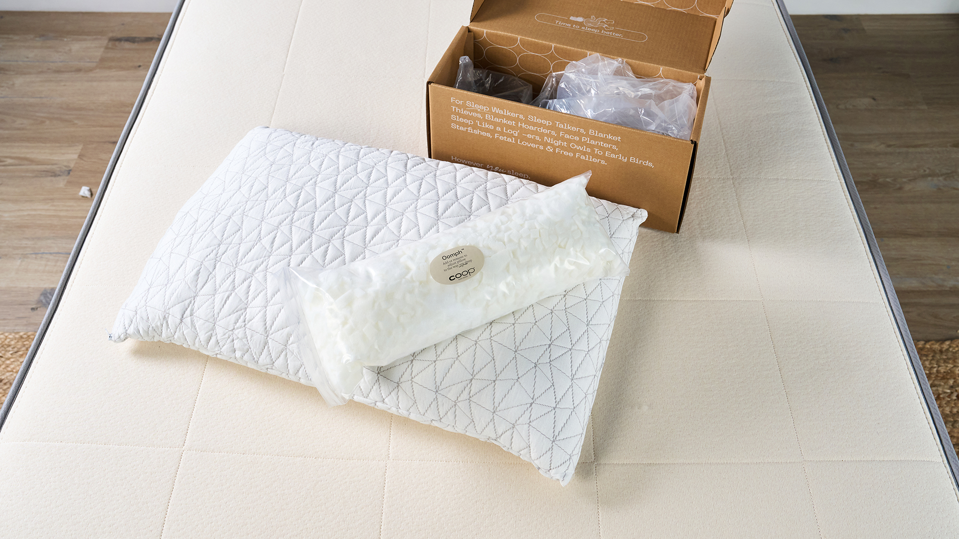 The Coop Original Adjustable white pillow and extra fill unboxed on a white sofa