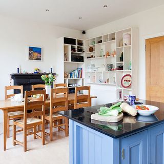 kitchen with island unit is pine table with matching chairs and alcove shelving wraps