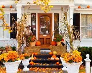 halloween porch decor with pumpkins and corn
