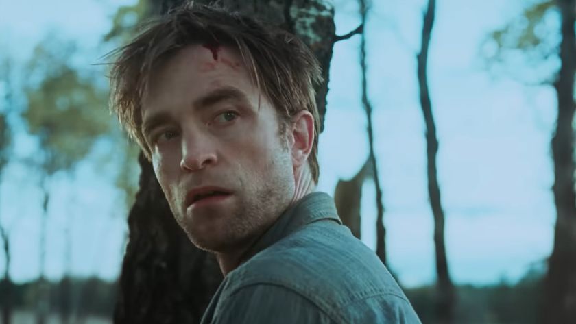 Robert Pattinson looks behind him in Die My Love, a look of horror and blood on his face.