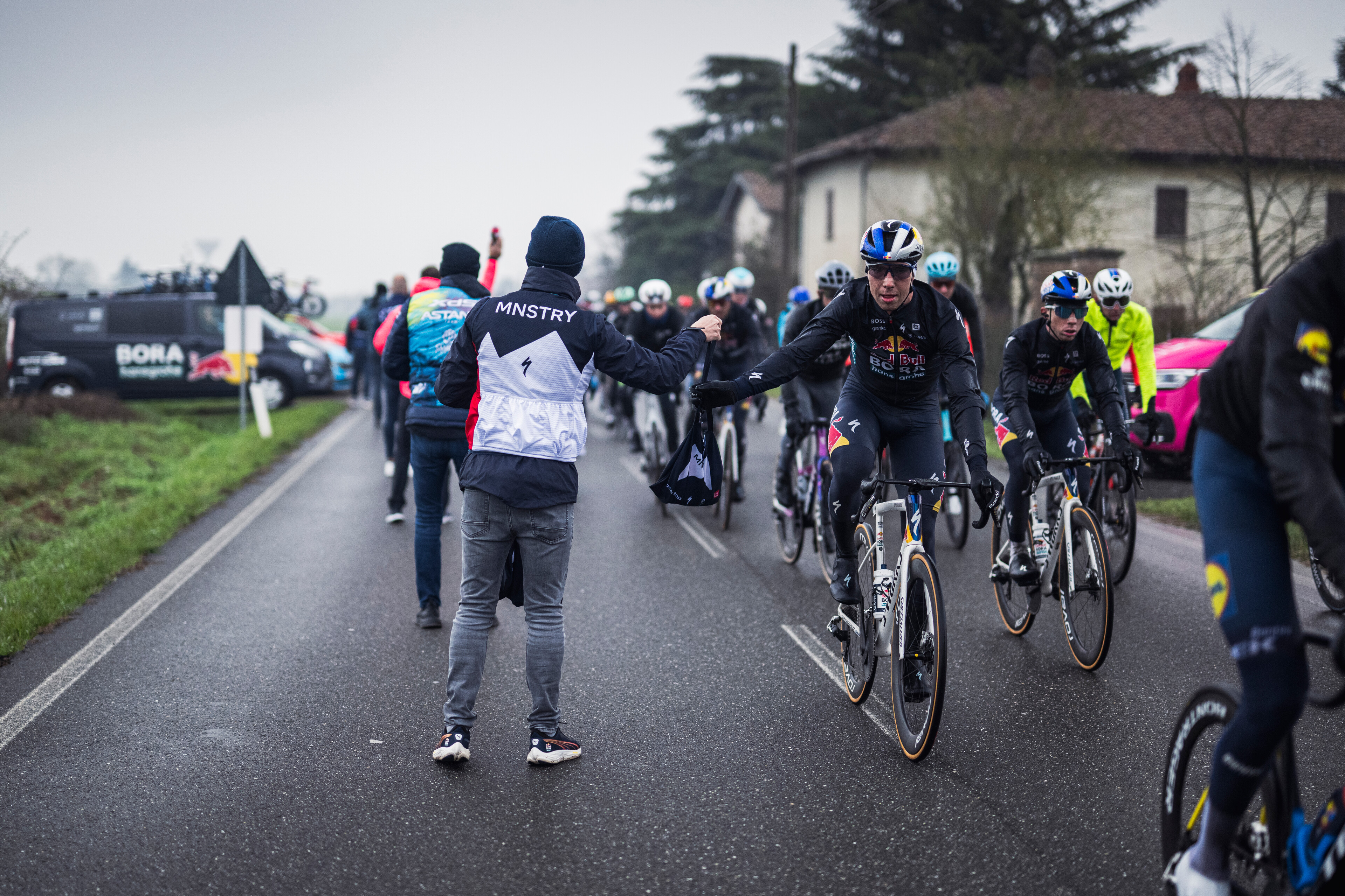 Filip Maciejuk collects some mid-ride supplies during Milan San-Remo
