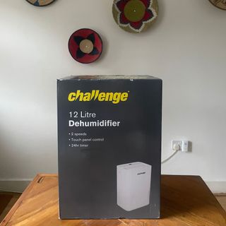 Challenge D015B 12L Dehumidifier box sitting on a wooden dining room table