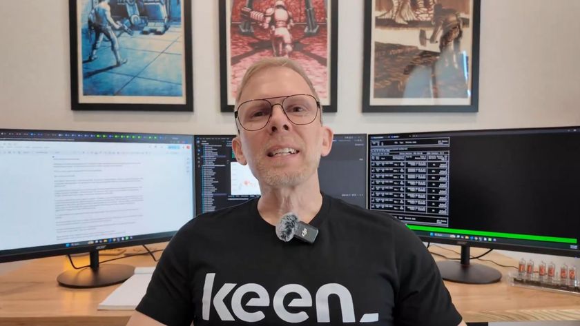 An image of John Carmack in front of three monitors