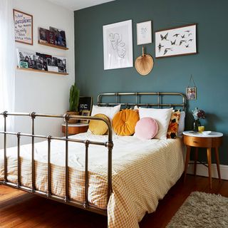 bedroom with green feature wall and metal bedstead