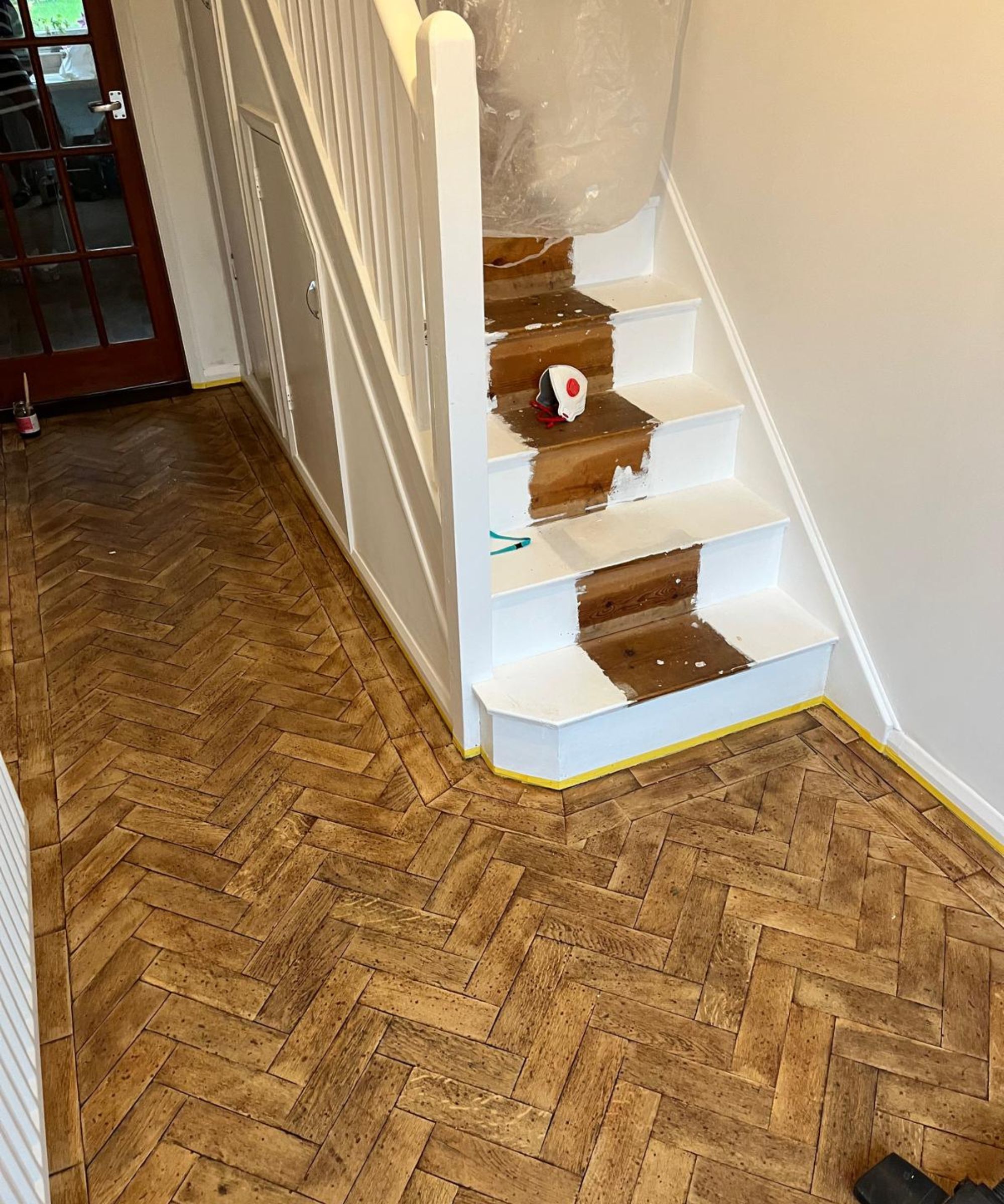 A vintage parquet floor being renovated via sanding and the application of wood dye
