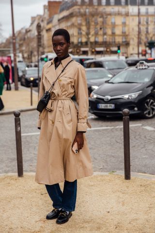 woman wearing trench coat, jeans, and loafers