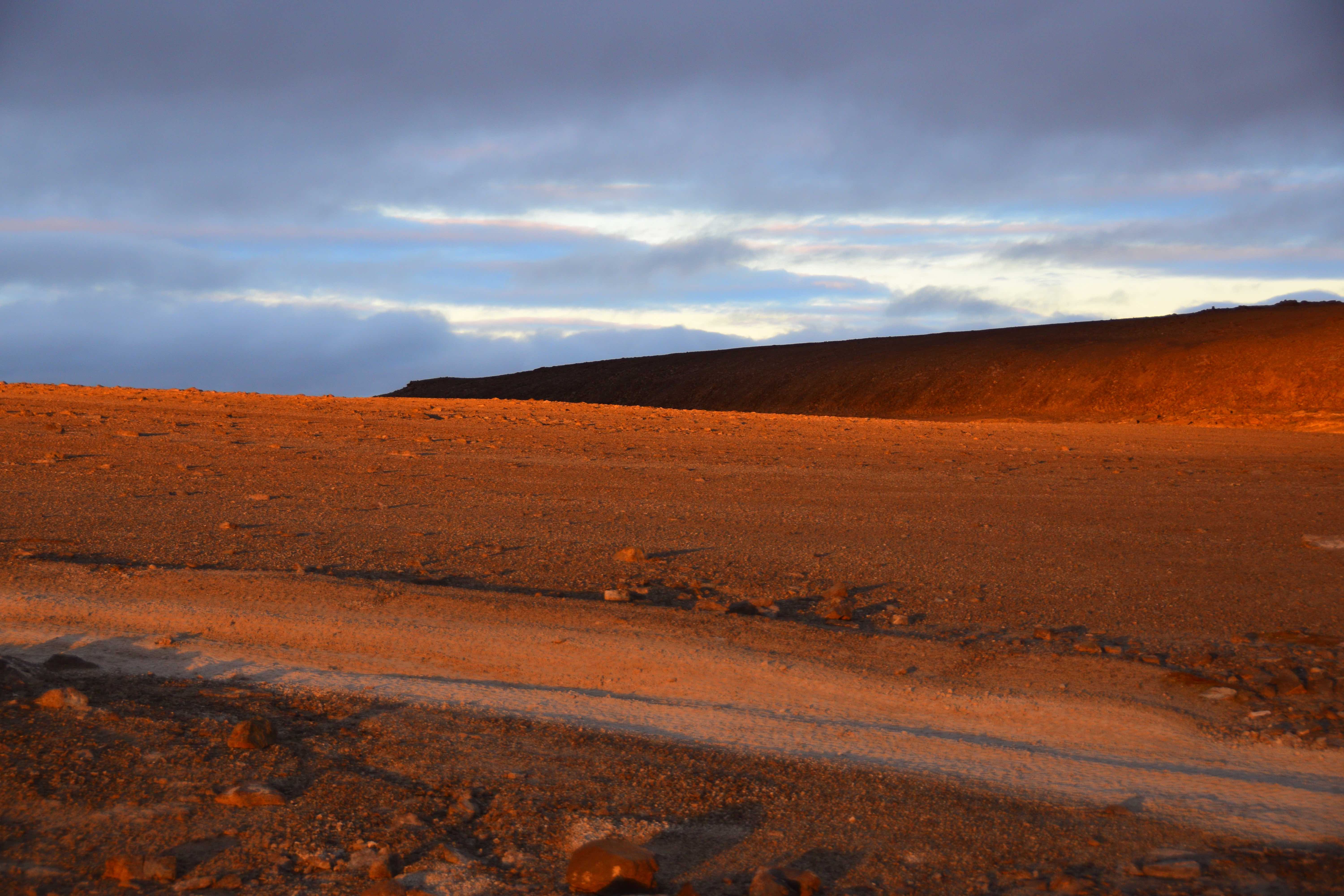 The terrain of Von Braun Planitia glows red at sunset.