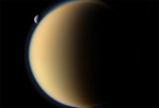 Titan with the small moon Tethys in the background.
