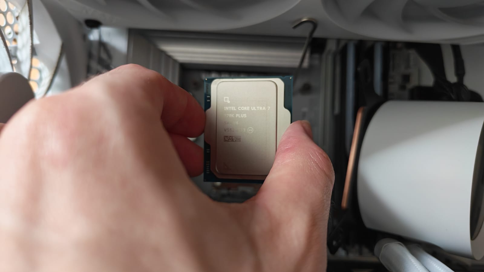 A reviewer about to place the Intel Core Ultra 7 270K Plus into its motherboard socket