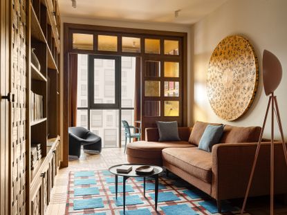 A living room with a brown sofa, and an in-built TV unit