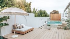A blond wood deck with an above ground pool