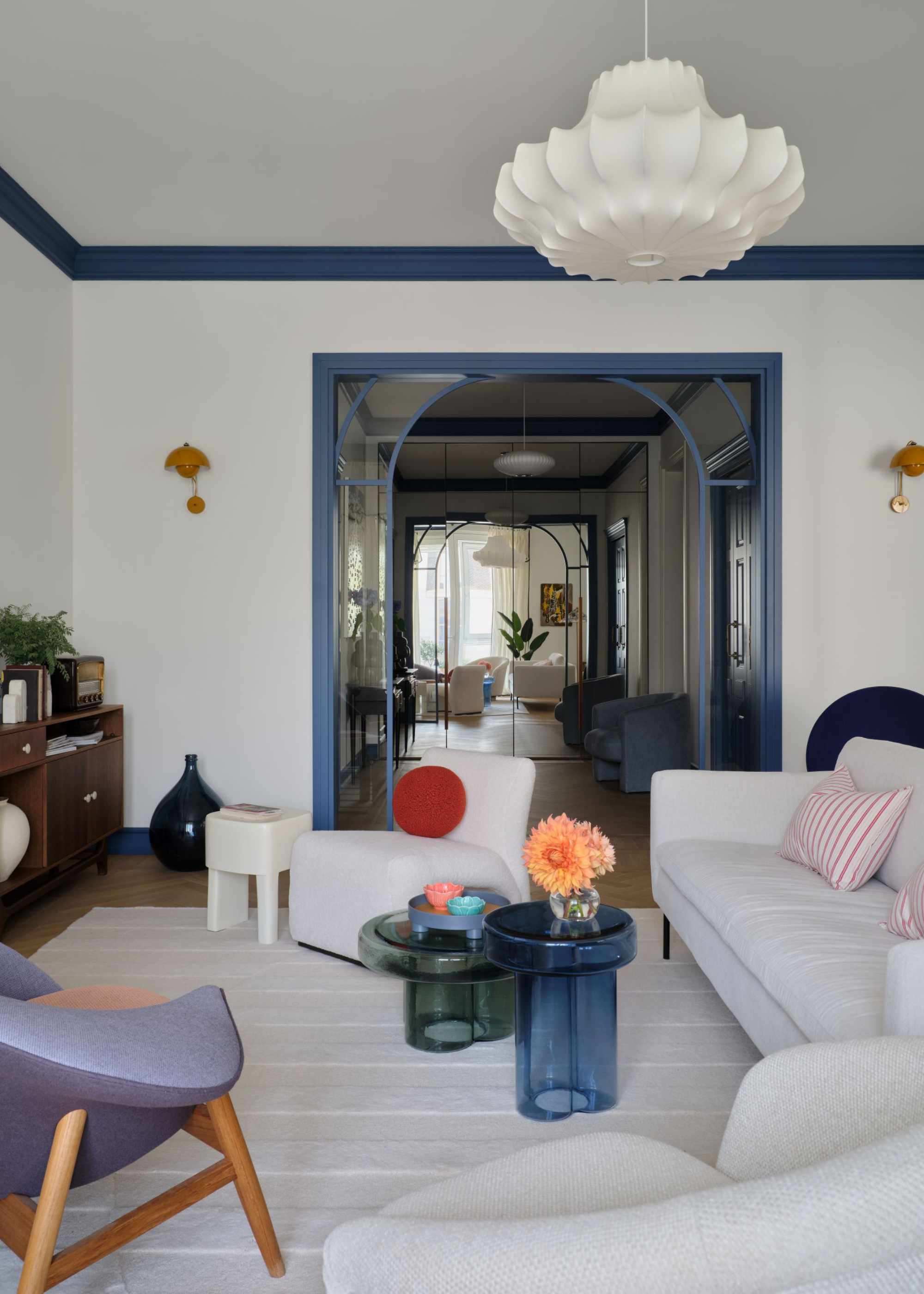 A beautiful, open living room with an arched entrance and unique, modern furniture pieces
