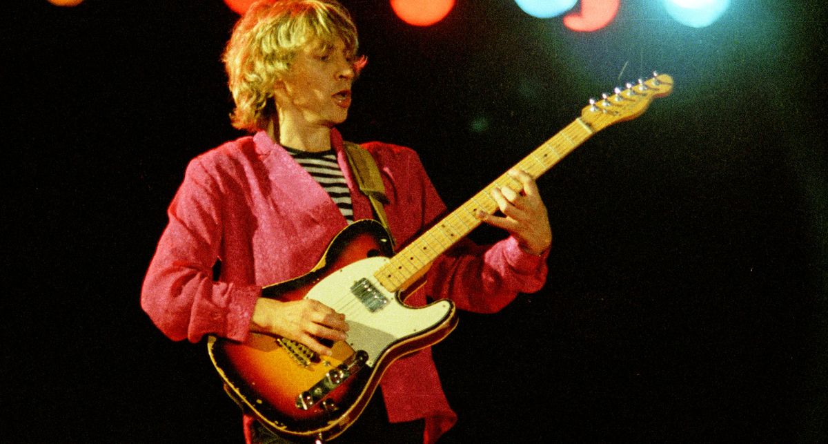 Andy Summers wears a pink blazer and breton striped shirt as he place his modded Telecaster at Reading Festival, 1979