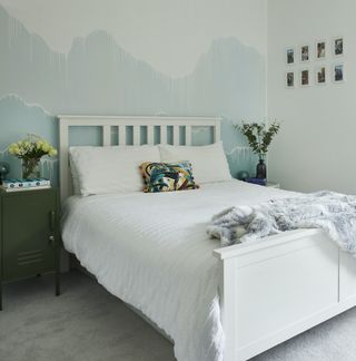 Bedroom decorated in watery blues with painted white bed