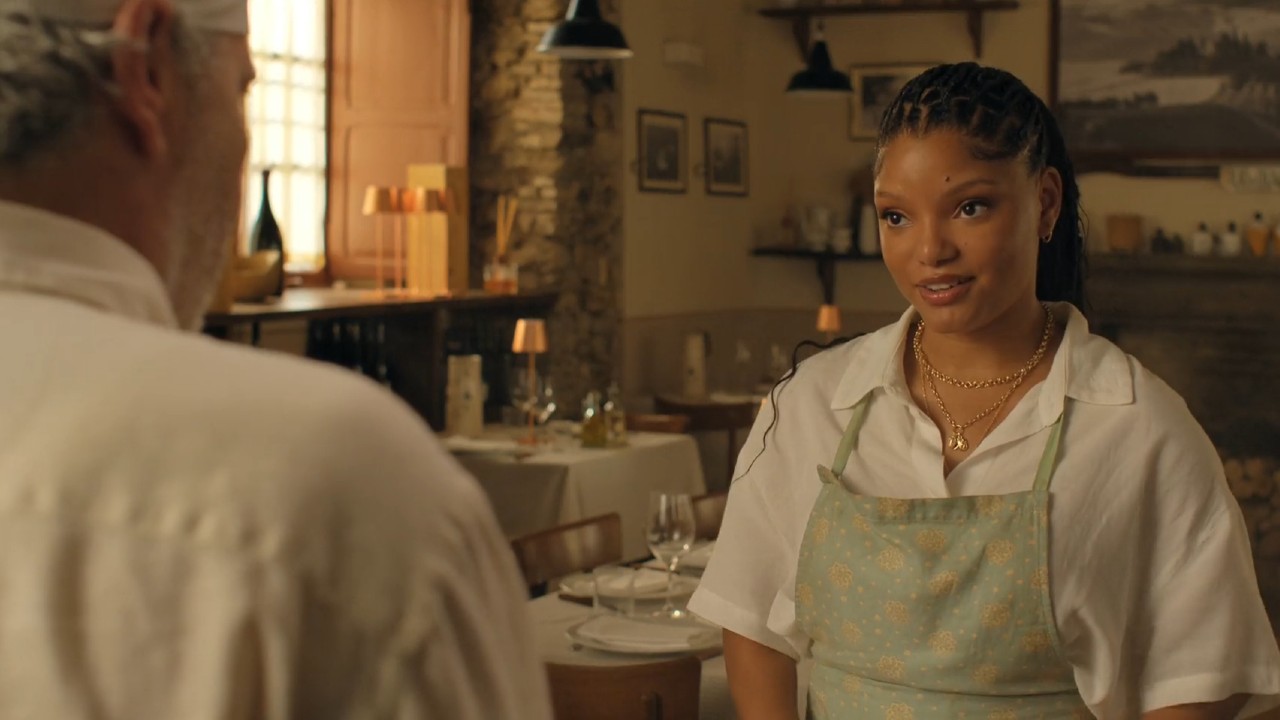 Paolo Sassanelli talking to Halle Bailey in You, Me, and Tuscany.