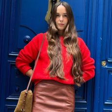 Woman in a red sweater and brown skirt