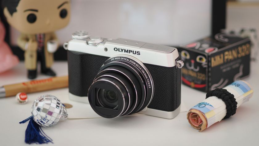 Lifestyle image of the Olympus Stylus SH-3 on a white surface